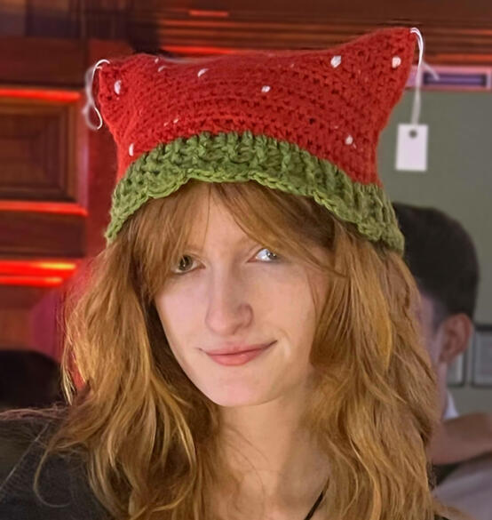 Image shows a person wearing a strawberry themed crochet cat hat